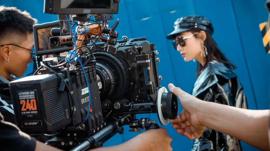Equipo de rodaje con una cámara RED y un foquista ajustando el follow focus mientras graban a una actriz